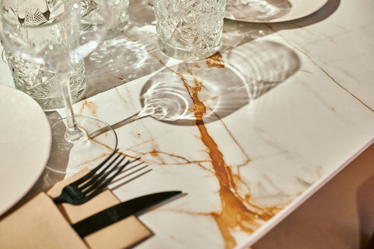 Reflejos de cristalería sobre mesa en Dekton de Cosentino fotografiada por Luis García Craus en el restaurante Santiago de Madrid.
