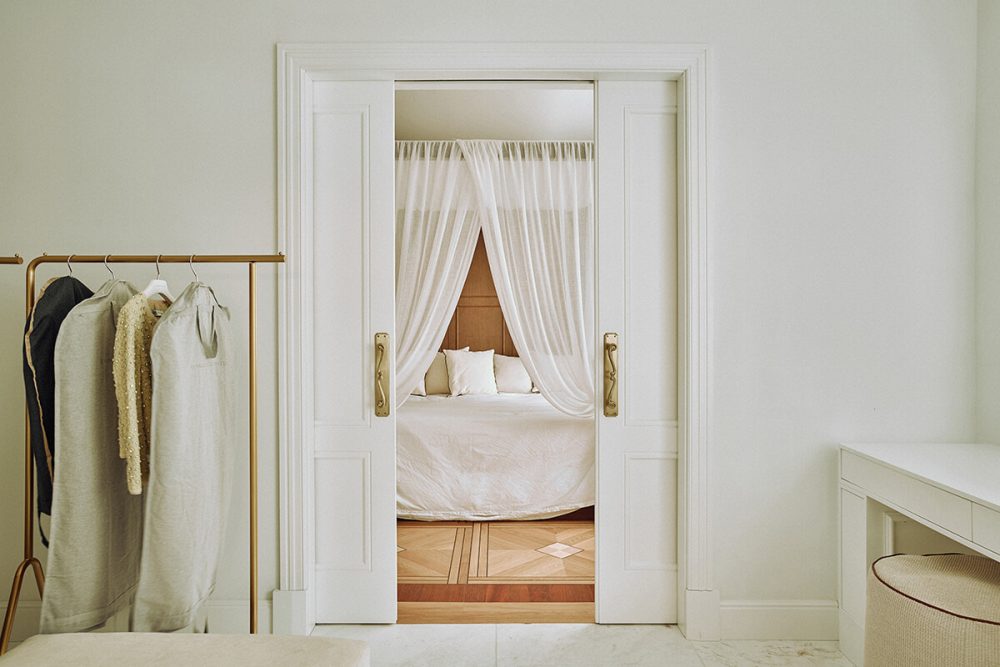 Dormitorio elegante con textiles blancos y carpintería a medida en vivienda de lujo